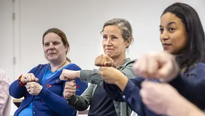 rie vrouwen maken samen een vuistgroet tijdens een oefening.