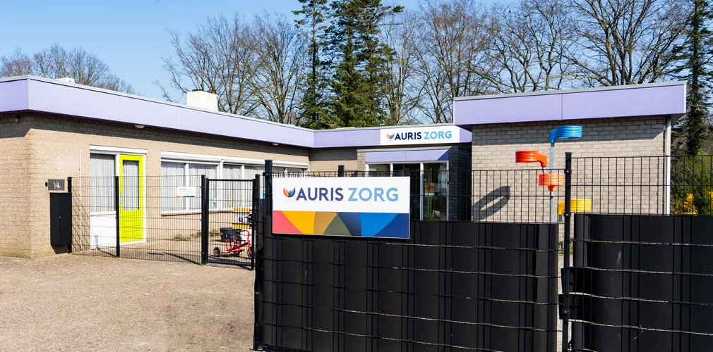 Bord met Auris Zorg op een hek