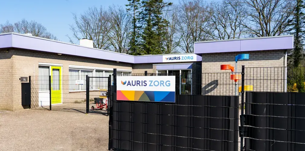 Bord met Auris Zorg op een hek