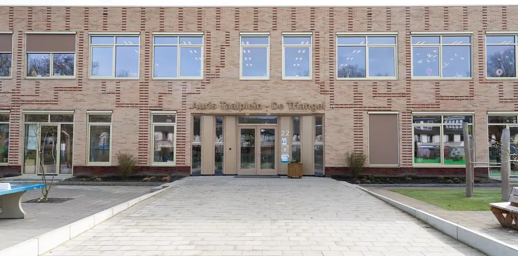 Voorkant schoolgebouw met Auris Taalplein op gevel
