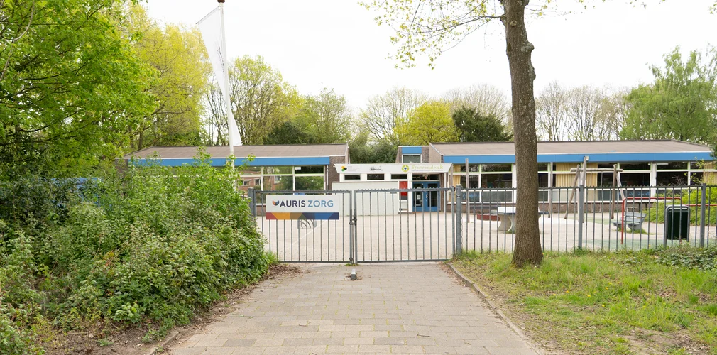 Hek met daarachter een gebouw