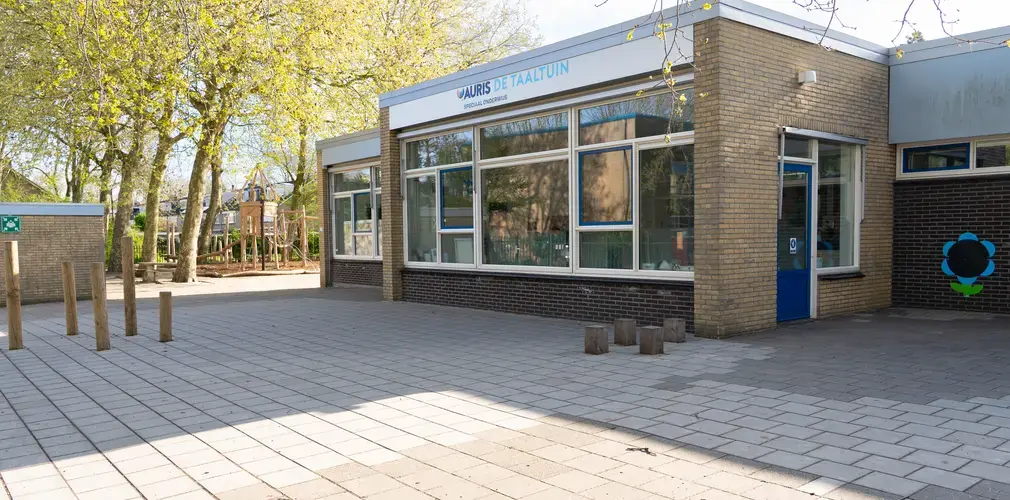 Vooraangezicht van schoolgebouw Auris De Taaltuin met speelplein