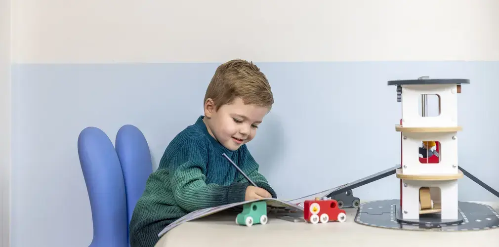 Een peuter schrijft in een boekje. 