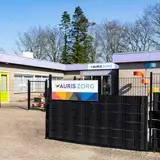 Bord met Auris Zorg op een hek