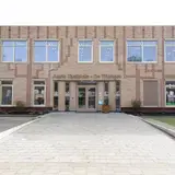 Voorkant schoolgebouw met Auris Taalplein op gevel