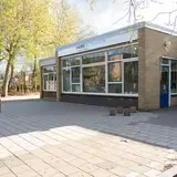 Vooraangezicht van schoolgebouw Auris De Taaltuin met speelplein