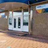 Grote witte deur in een stenengebouw met bord op de gevel