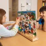 Twee kinderen spelen samen met een taalspel met een boerderijplaat en gekleurde pinnen aan tafel.