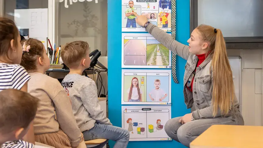 Leerkracht geeft les met visuele woordkaarten aan een groep leerlingen.