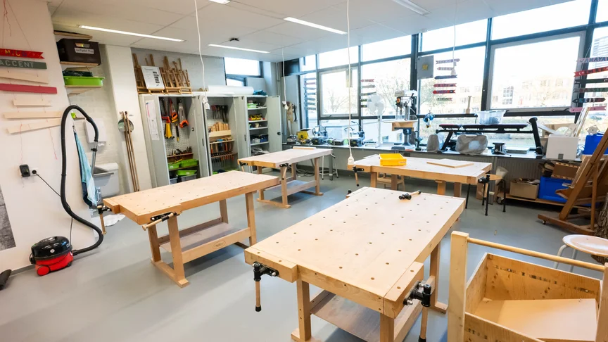 Een lege werkplaats met houten werkbanken en gereedschap 