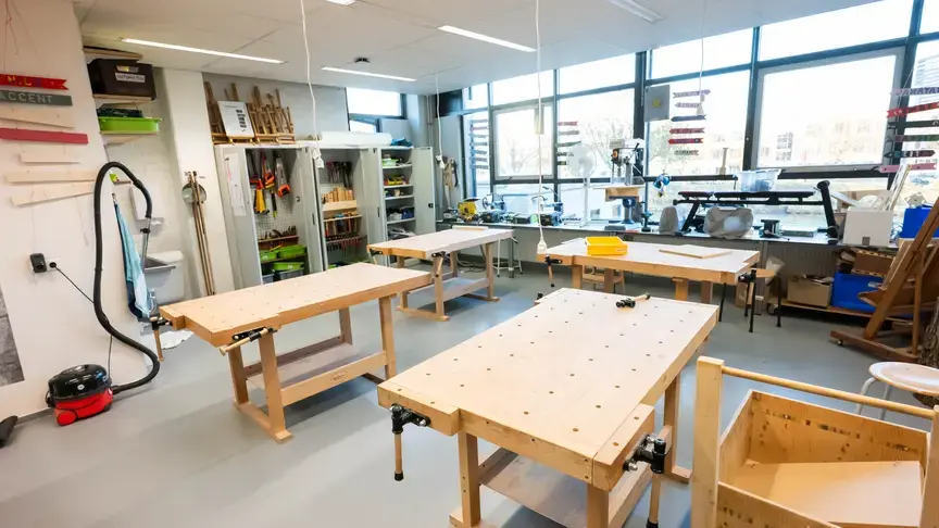 Een lege werkplaats met houten werkbanken en gereedschap 
